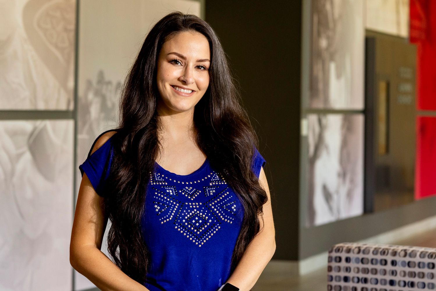 Dr. Jessica Comolli poses for a close-up profile photo. She is wearing a dark blue shirt and has long dark hair.