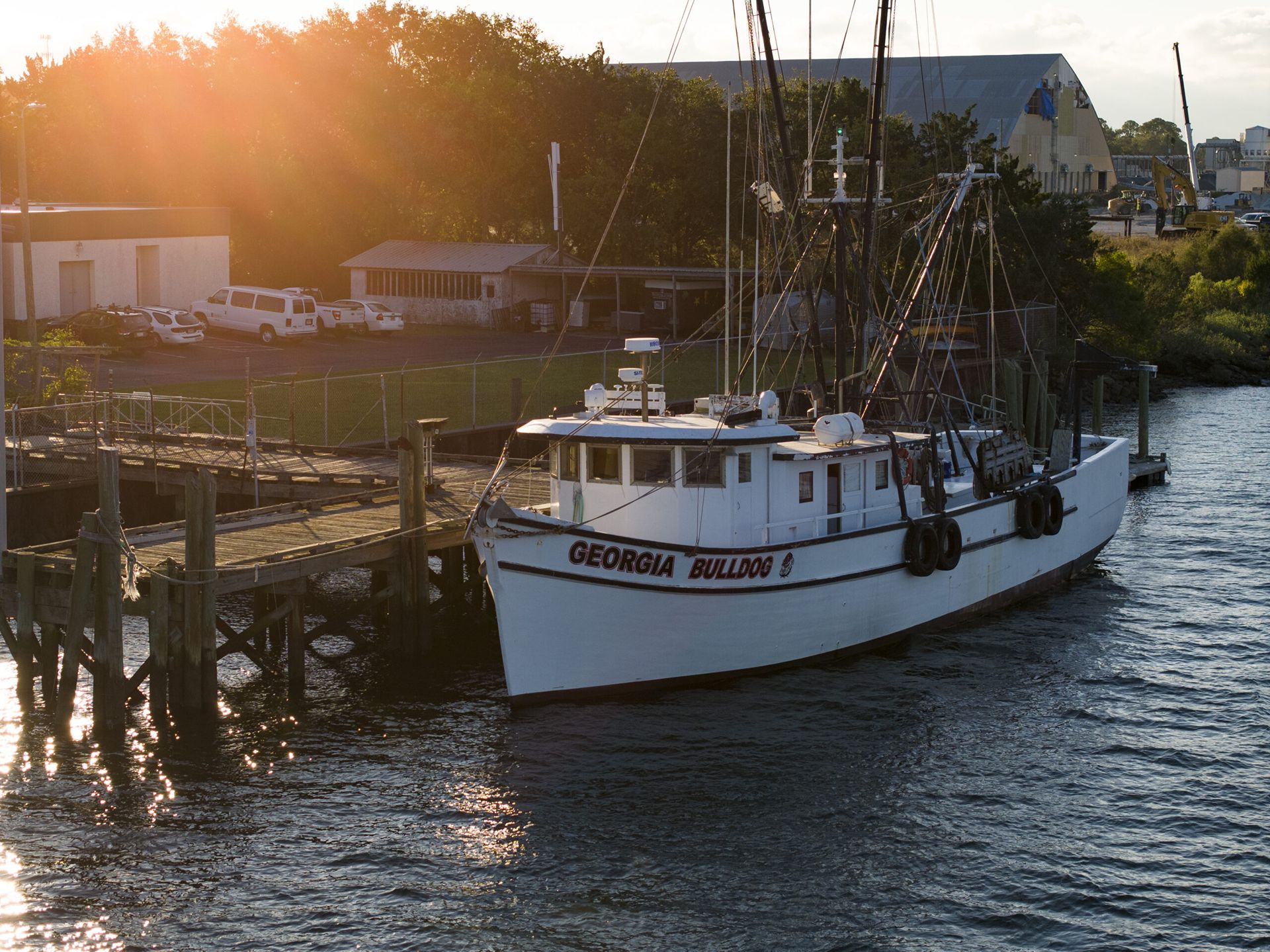 A ship named the "Georgia Bulldog" is docked at a wooden pier.