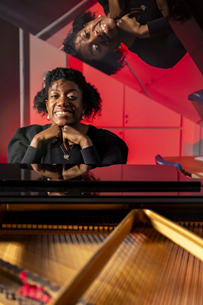 Environmental portrait of graduate student Asia Passmore at a piano at the High Hodgson School of Music building.