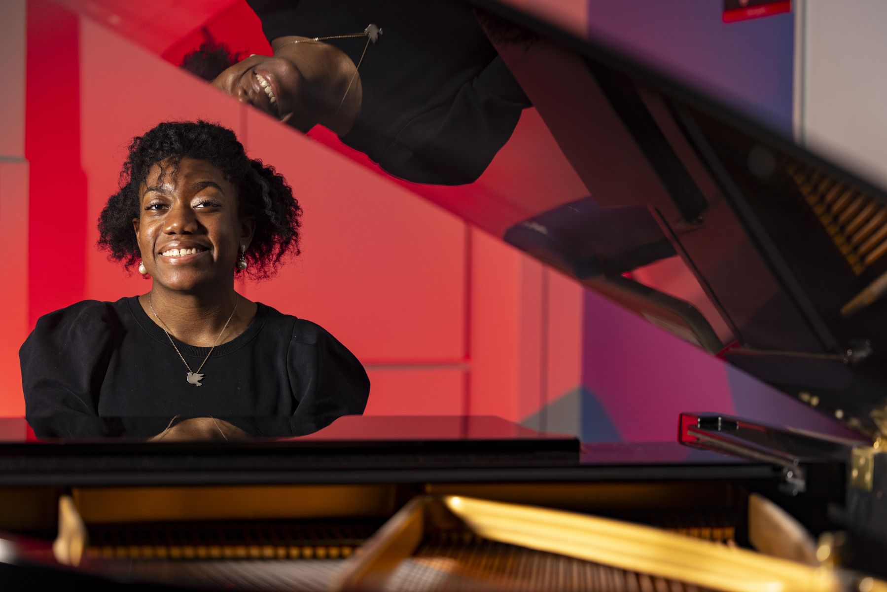 Environmental portrait of graduate student Asia Passmore at a piano at the High Hodgson School of Music building.