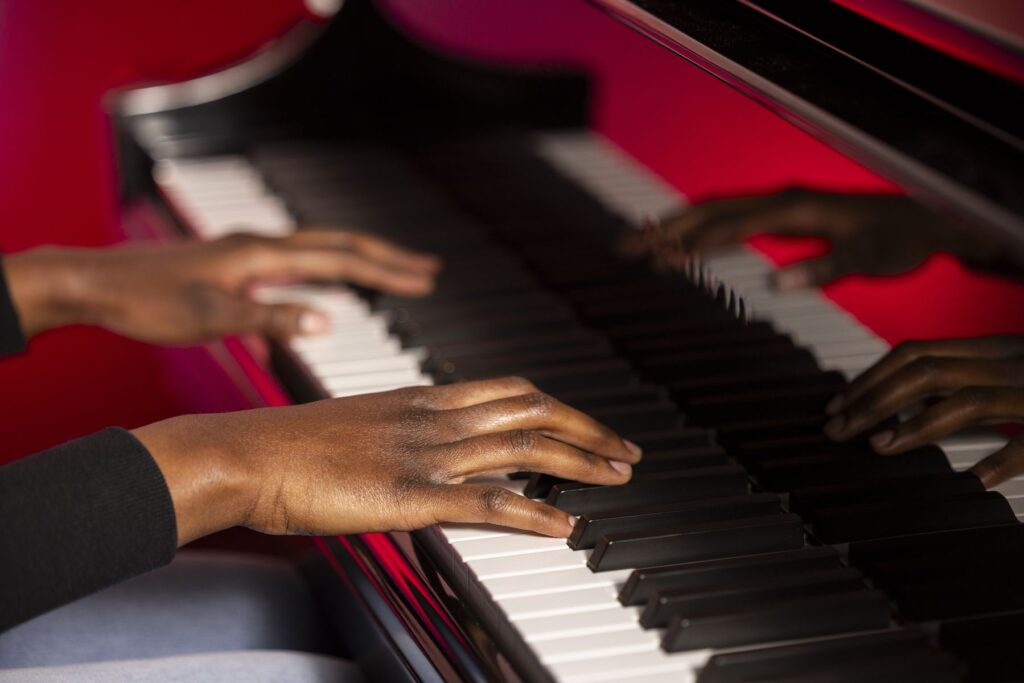 A closeup of Asia Simone Passmore's hands as she plays the piano.