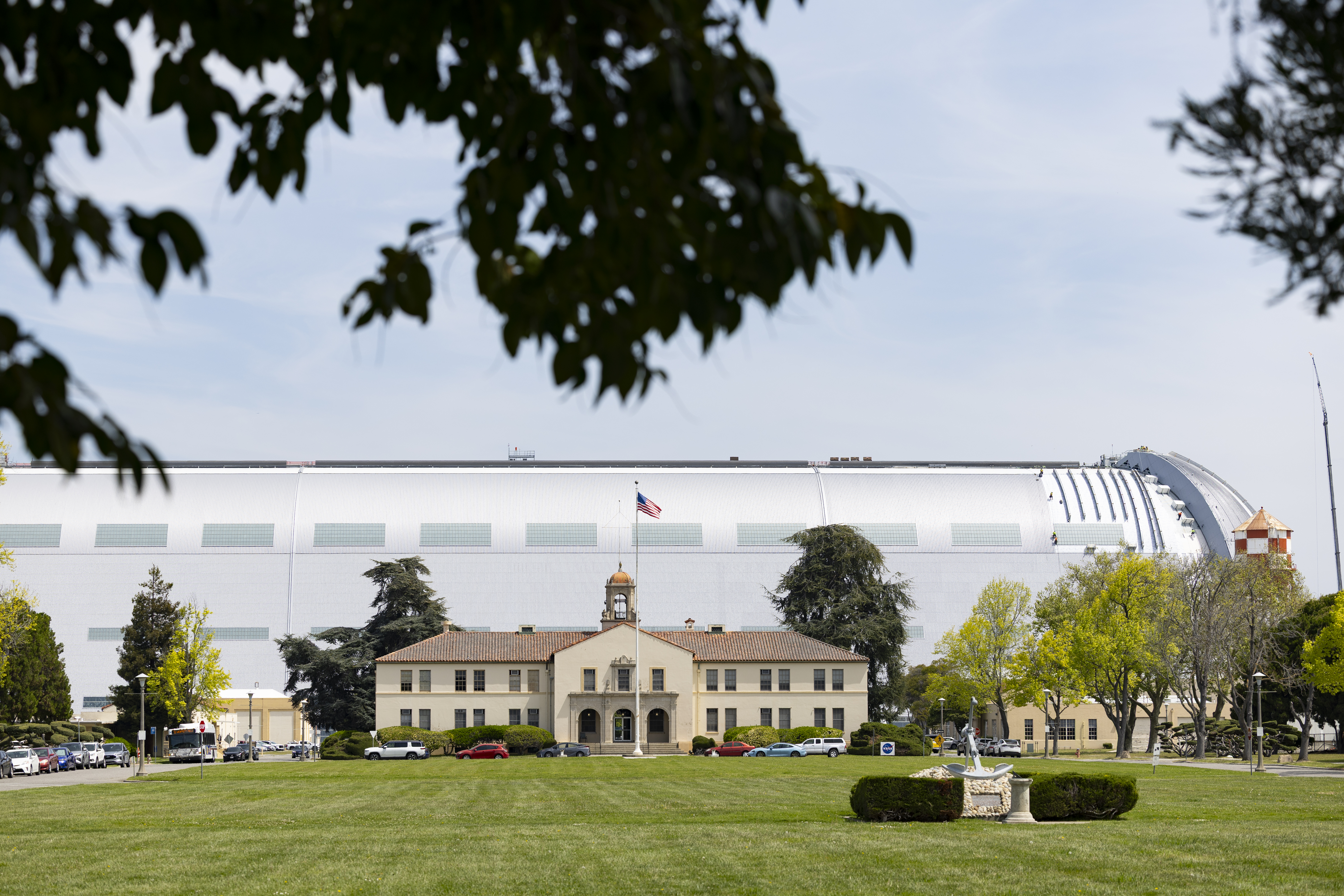 A zoomed-out view of a small academic building in front of a large tubular glass building.