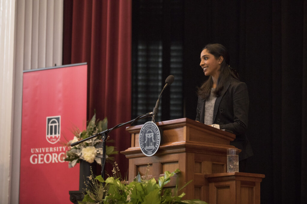 A young woman stands at a podium at UGA.