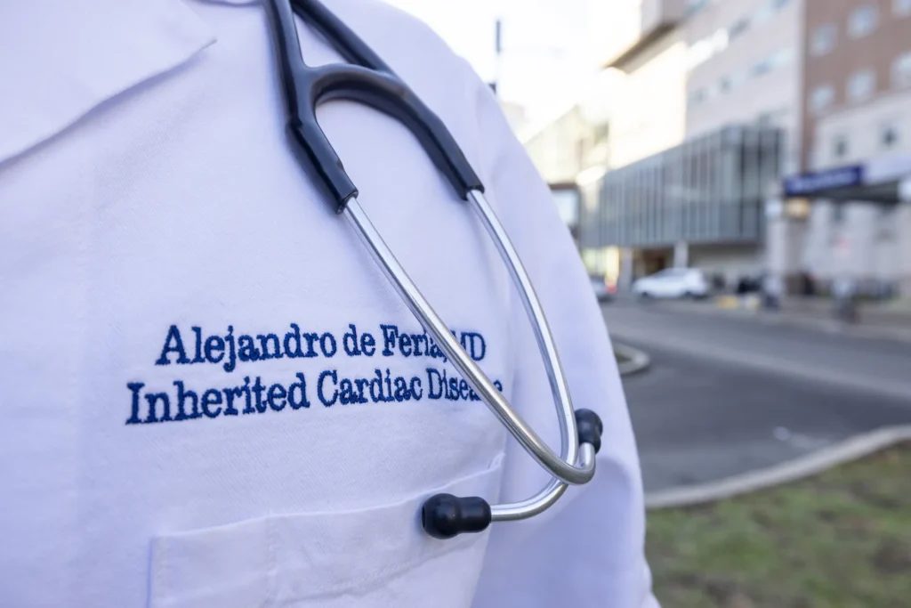 A close-up of Alejandro de Feria's white medical coat and stethoscope.
