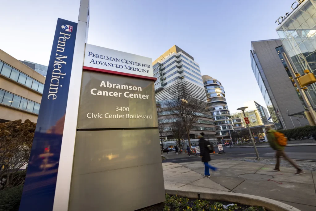 Several buildings behind a sign for the Abramson Cancer Center.