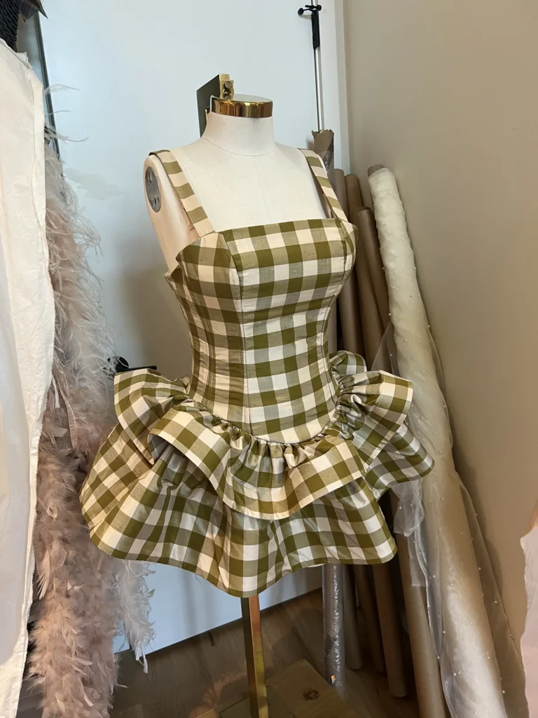 A short gingham dress on a dress form.
