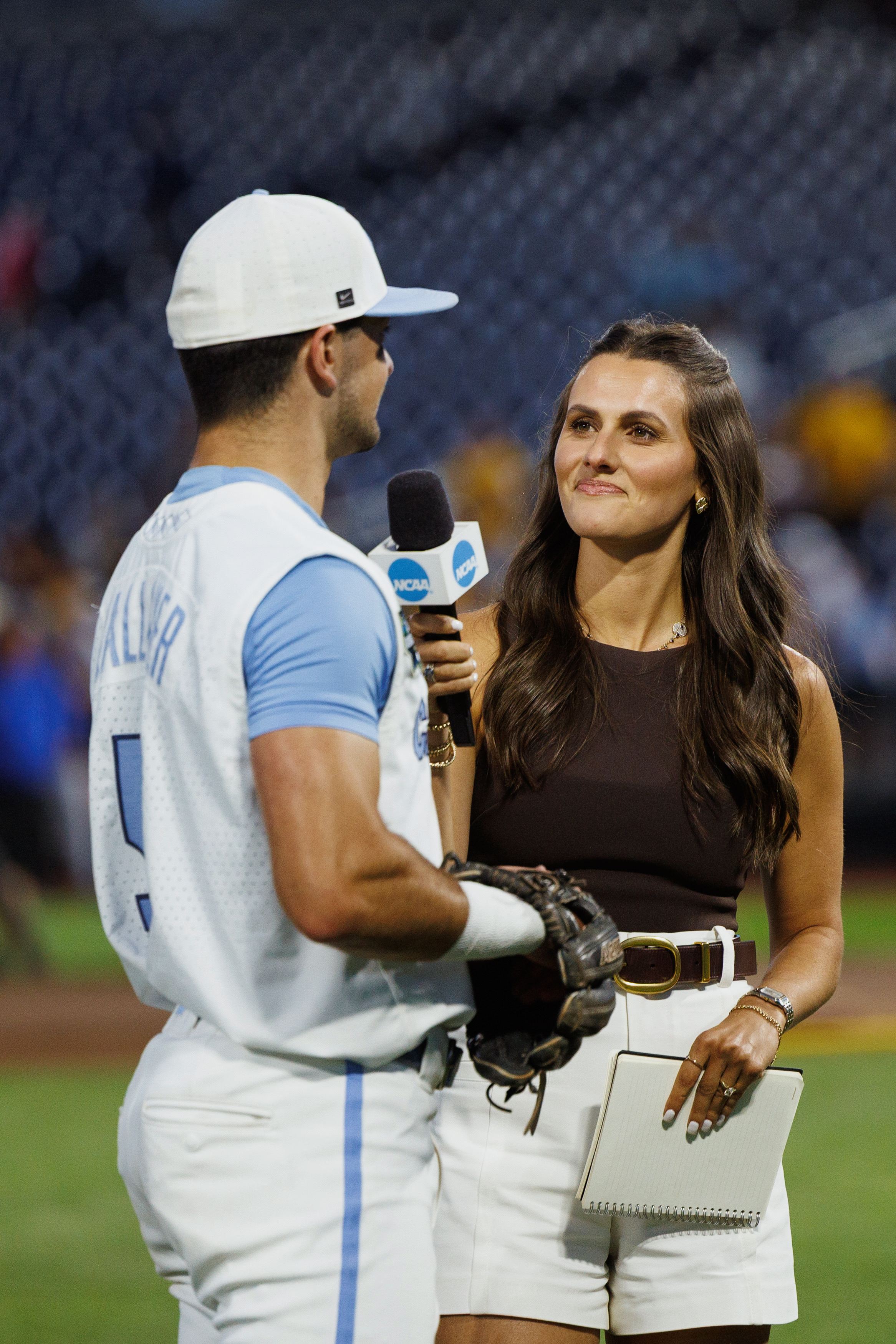 A woman interviews a University of North Carolina baseball player.